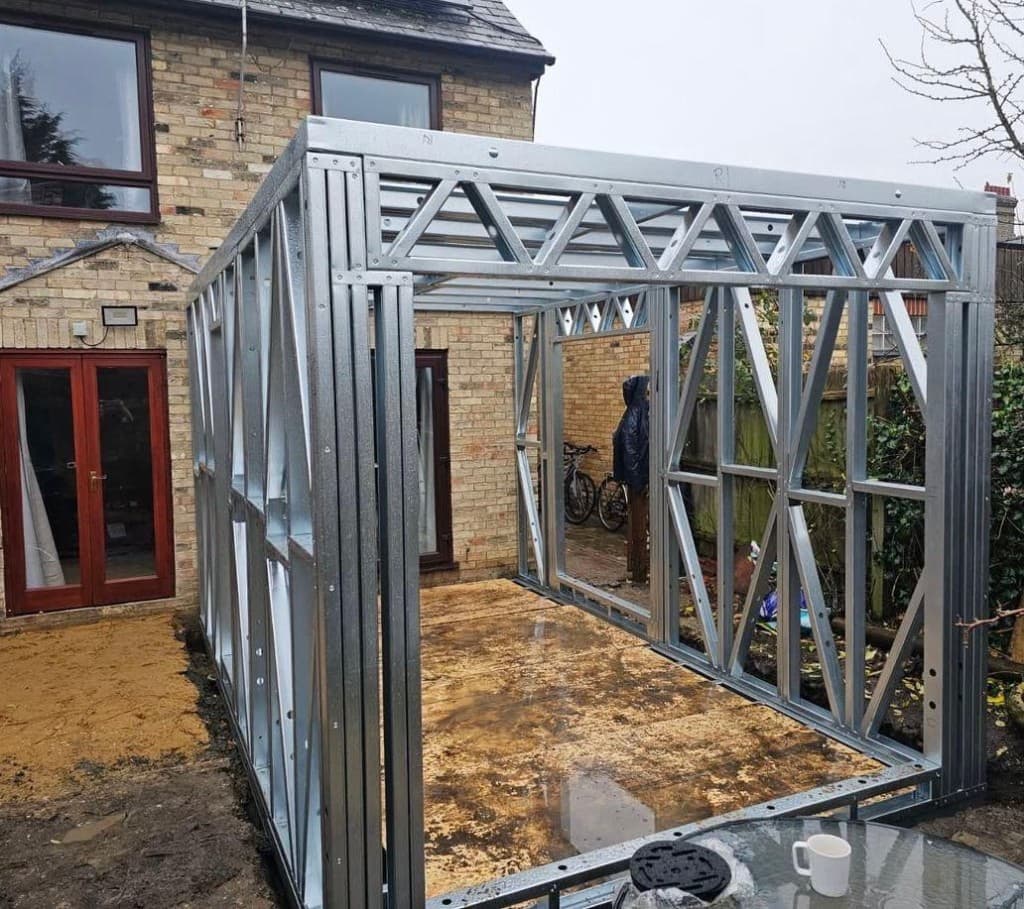Completed white rendered home extension with sliding doors and stone patio