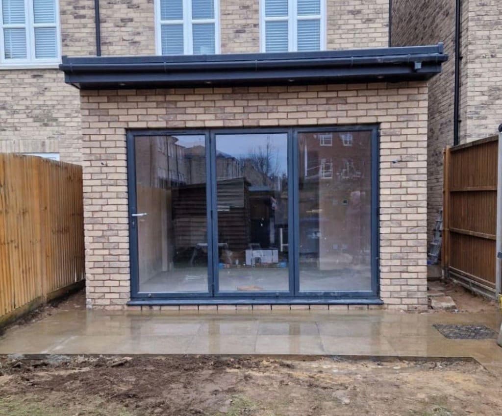 Steel frame extension with bi-fold door opening at a brick home