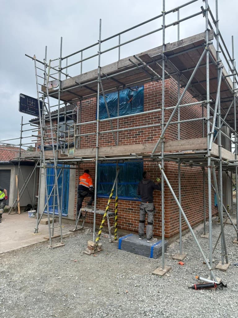 Wide view of steel frame extension structure on a residential build site